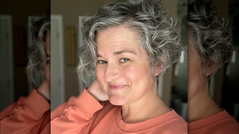 A woman with gray hair and a momager crop