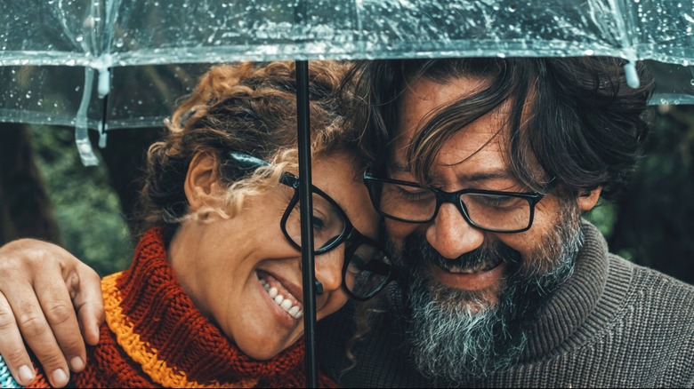 Smiling couple sharing an umbrella