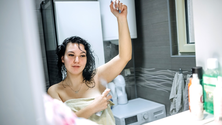 A woman applying deodorant