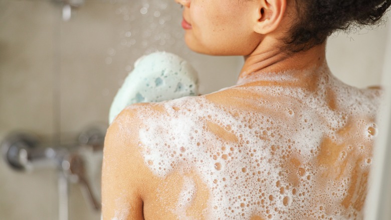 woman washing in shower with sponge