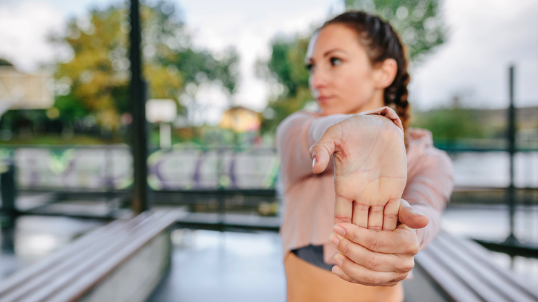 woman stretching her wrist outside