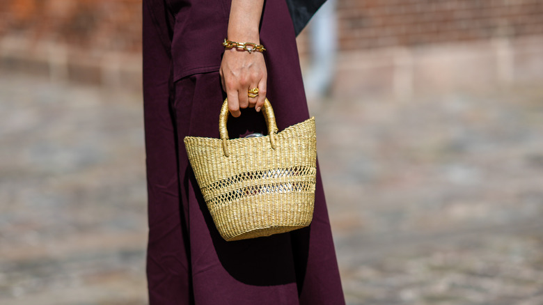 woman holding straw bag