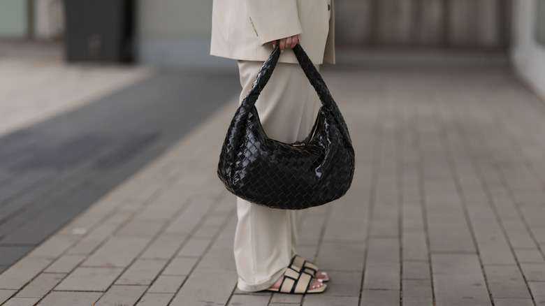 woman holding black Bottega bag