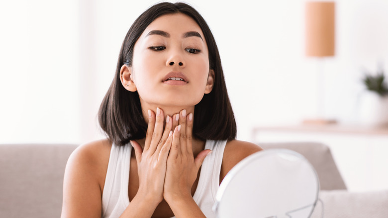 A woman moisturizing her neck