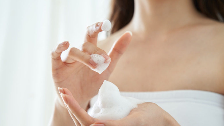 A woman holding some cleanser