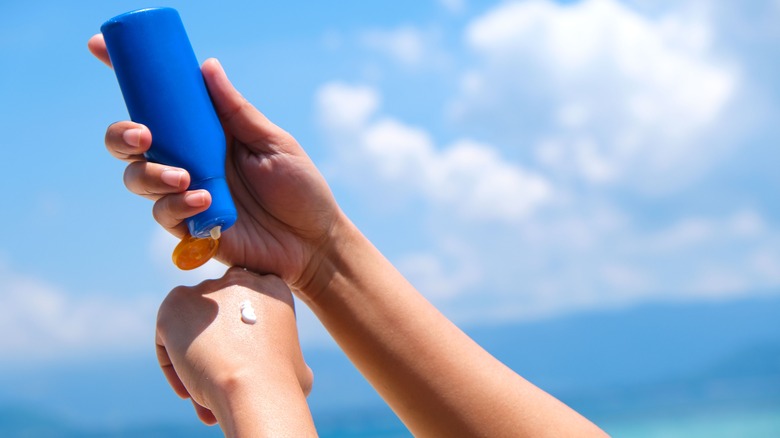 woman applying sunscreen on hands 