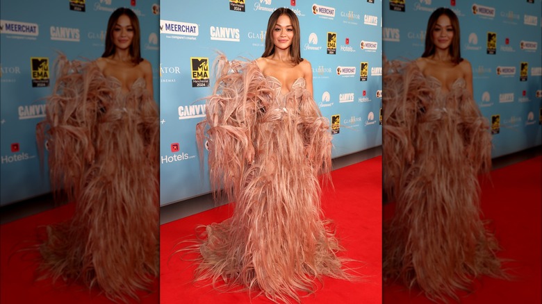 Rita Ora wearing a pink feathered dress on the red carpet.