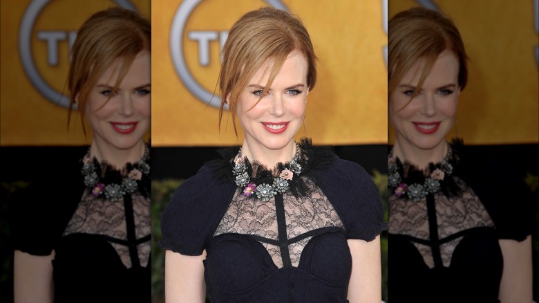 Nicole Kidman wearing a black dress with lace panels and a chunky floral necklace