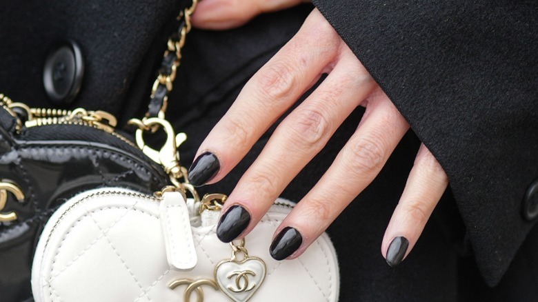 Hand with short black painted nails