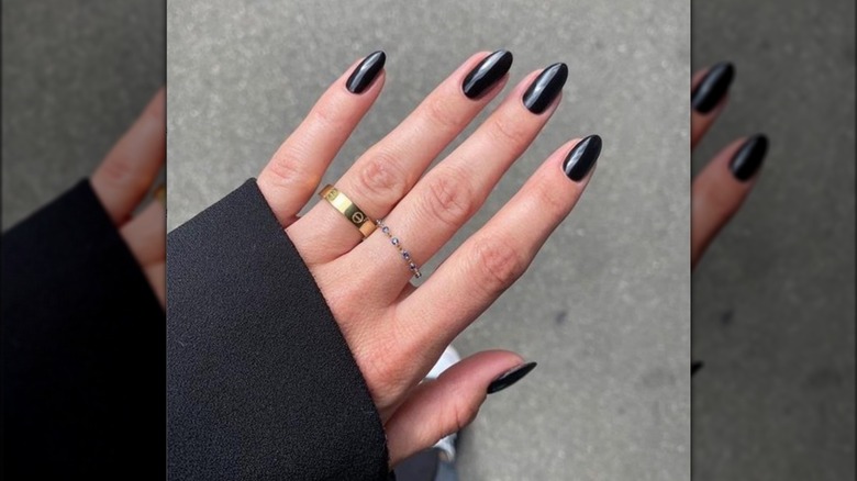 Manicured hand with black nail polish