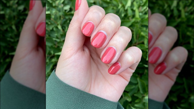 Hand with coral colored nail polish 
