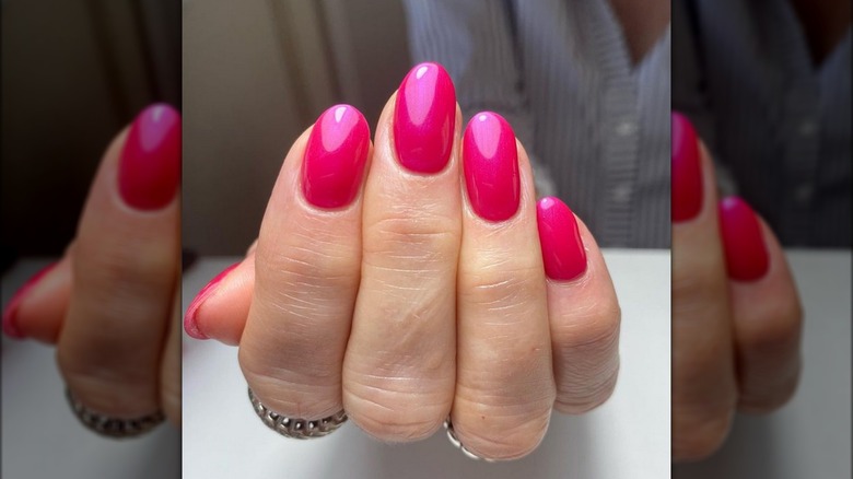 Almond shaped nails painted hot pink 