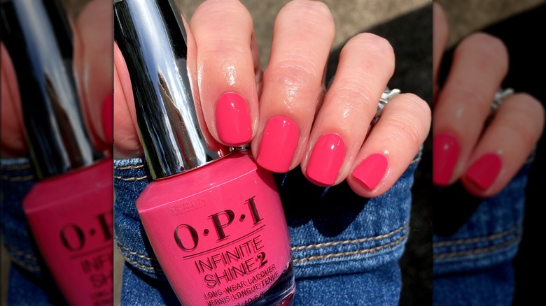 Hand holding pink OPI nail polish bottle 