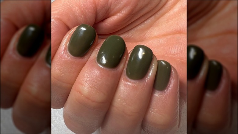 Manicured hand with green nails 