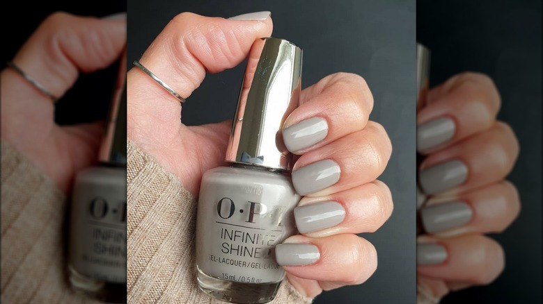 Hand holding grey OPI nail polish