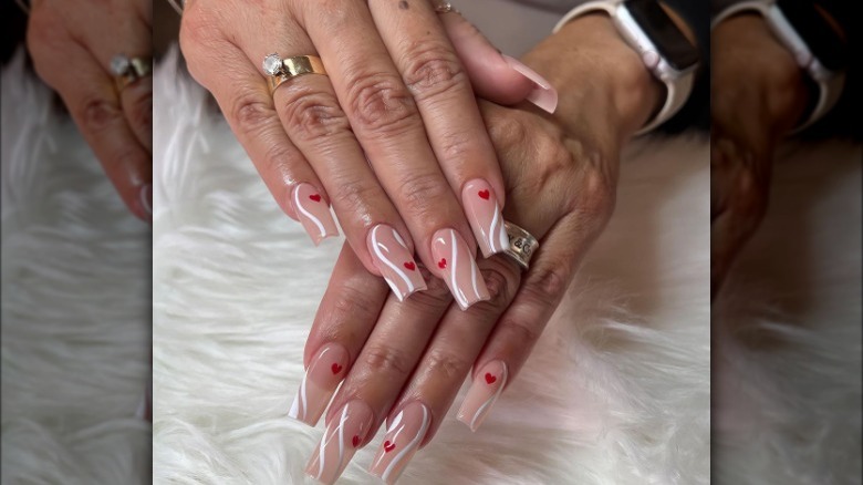 White swirls and red hearts manicure