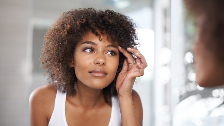 woman fixing her eyebrows