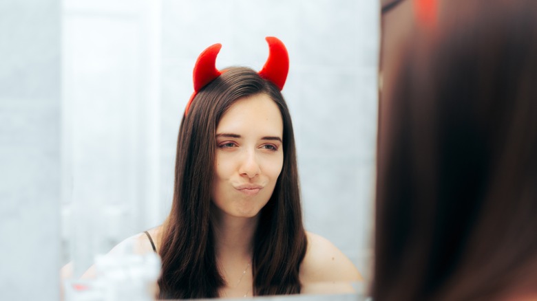 woman wearing devil horns