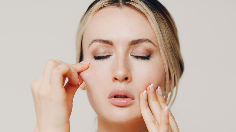 Model doing facial exercises