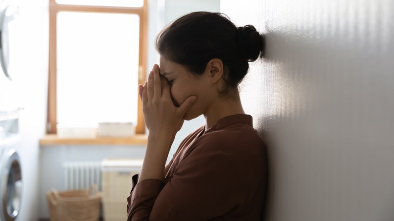 Woman upset standing by wall