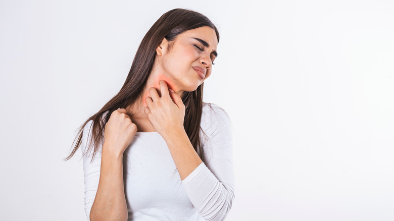 woman scratching itchy neck 