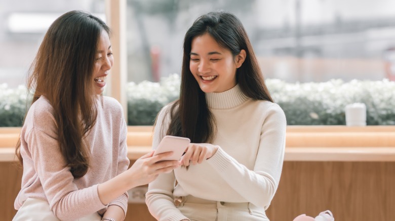 Two friends laughing at phone