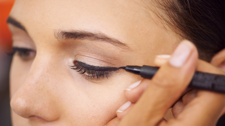 woman getting liner applied