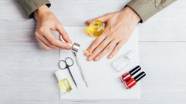 woman applying oil to nails