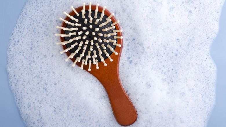 hairbrush in soapy water