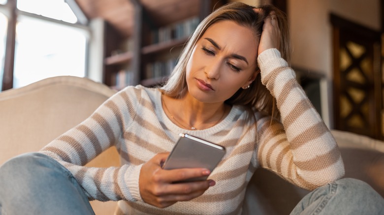 confused woman holding phone