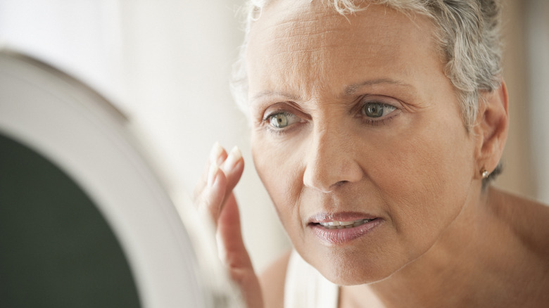 Woman applying skincare to face