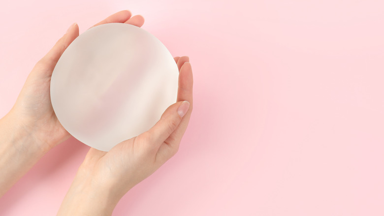 Model holding silicone breast implant
