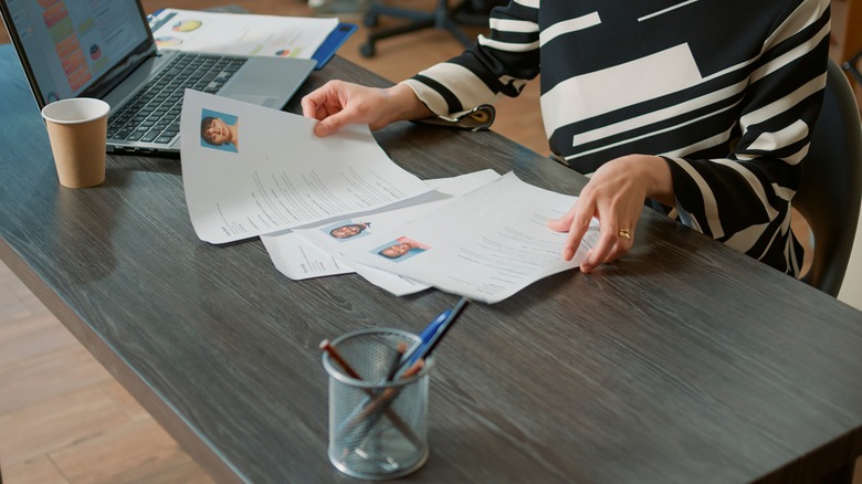 Closeup of hiring manager comparing resumes