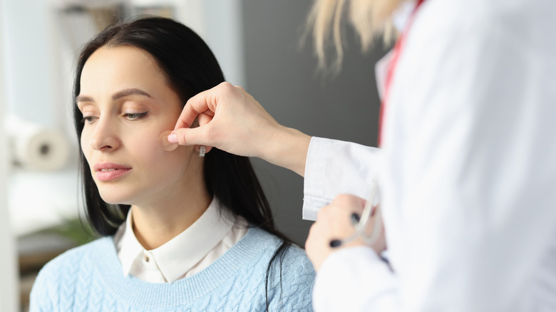 Doctor applying pimple patch to patient