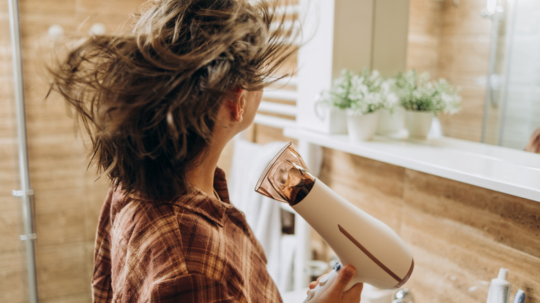 a woman blow drying her hair