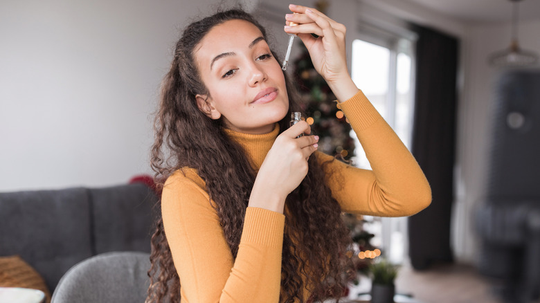 Girl holding essential oil dropper