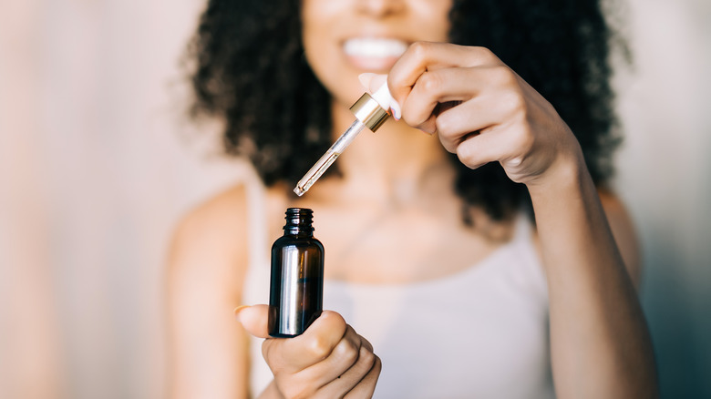 Woman applying rose petal oil