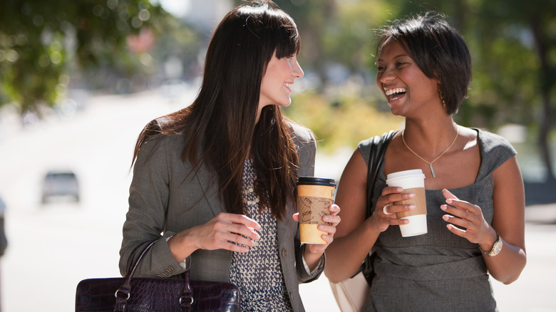Coworkers share coffee in parking lot