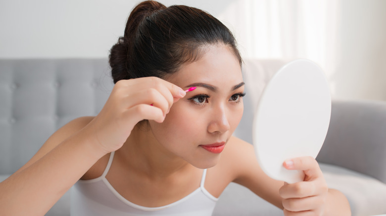 woman use q tip on eyebrow