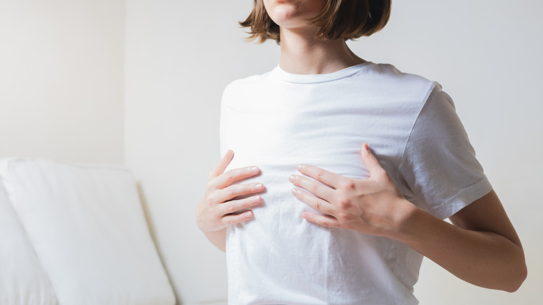 Woman covering breasts with hands