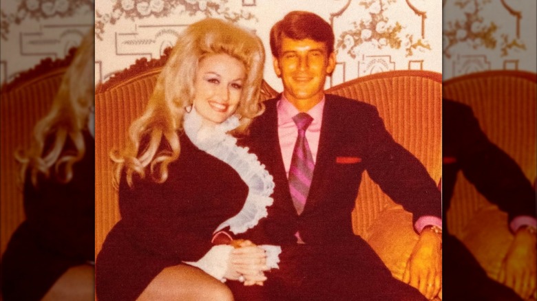 Dolly Parton sitting on a sofa with husband Carl Dean.