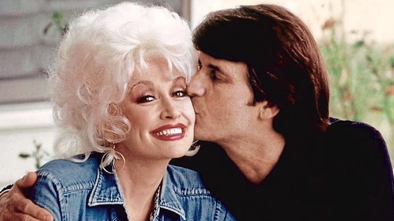 Carl Dean kissing Dolly Parton on the cheek.