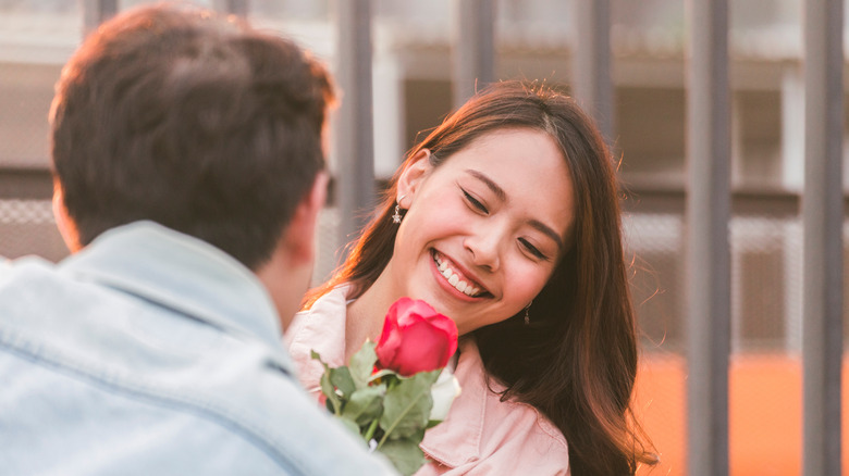 man giving woman a rose