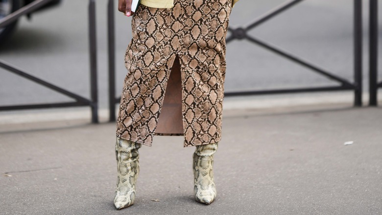 Person in snakeskin skirt, boots