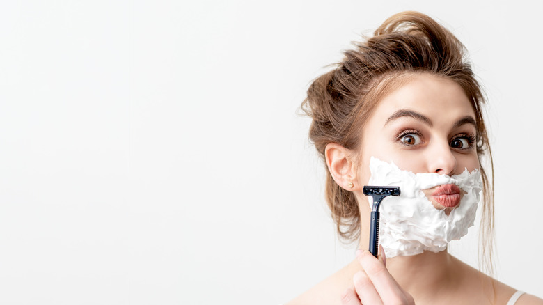 Woman shaving with shaving cream