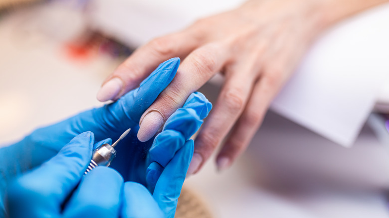 women removing nail cuticles 