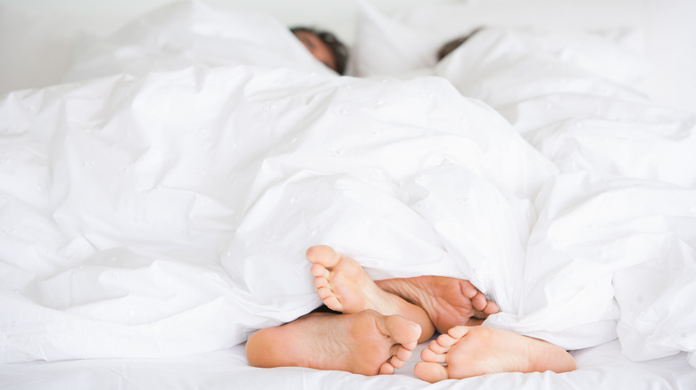 Couple in bed with feet sticking out