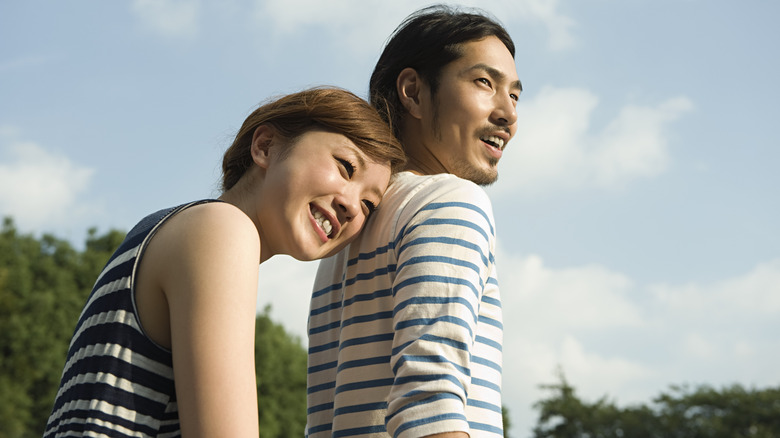 A woman leaning her head on her partner's shoulder.