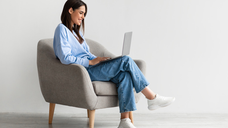 Woman happily shops on laptop