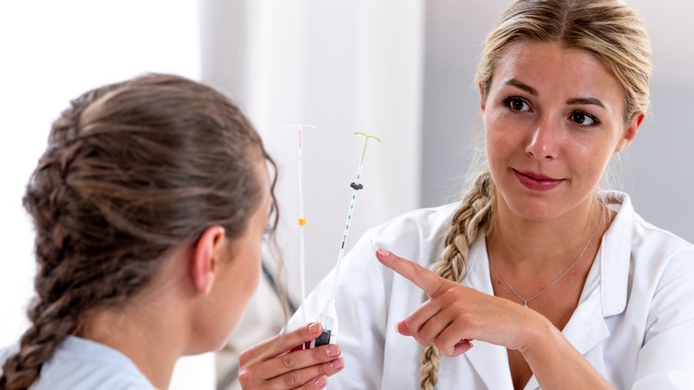 female doctor holding two IUD options talking to patient